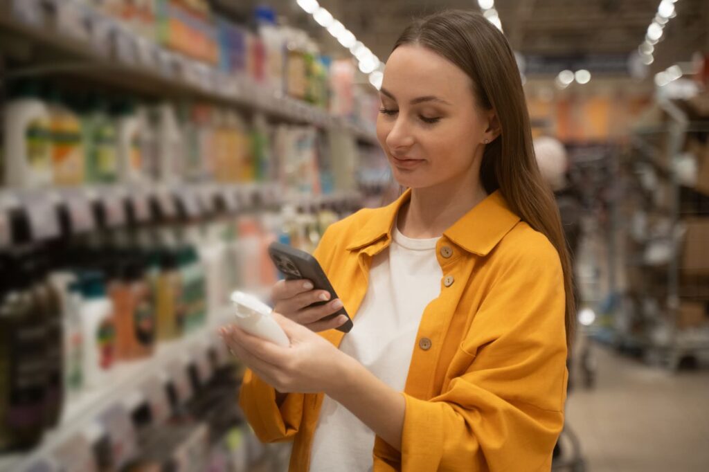 consumer lady in a retail aisle looking up essential items